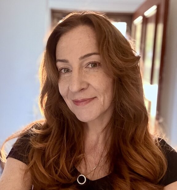 48 year old red headed woman smiling at the camera